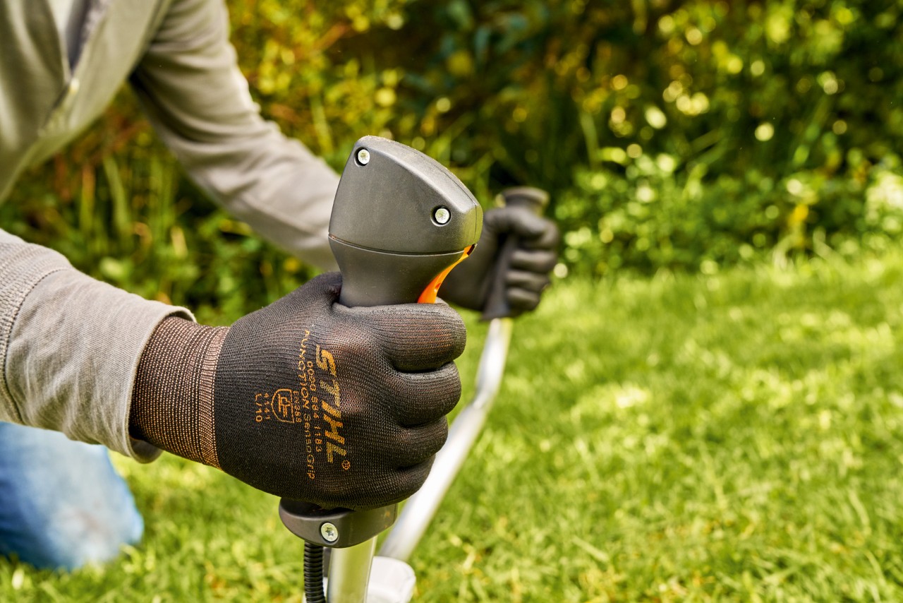 Un hombre arranca brevemente el motor de la desbrozadora de gasolina STIHL FS 91