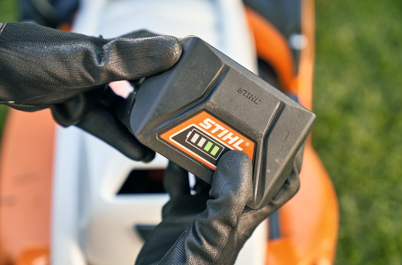Batería de litio-ión STIHL, en segundo plano un cortacésped a batería STIHL RMA 339 C