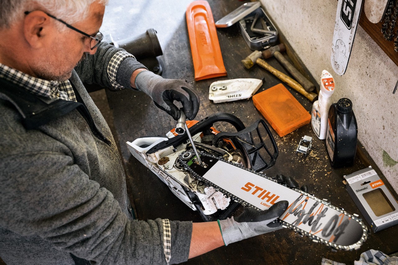 Un distribuidor STIHL realiza el mantenimiento de una motosierra que cuenta con una espada STIHL Light 04 y una cadena Oilomatic
