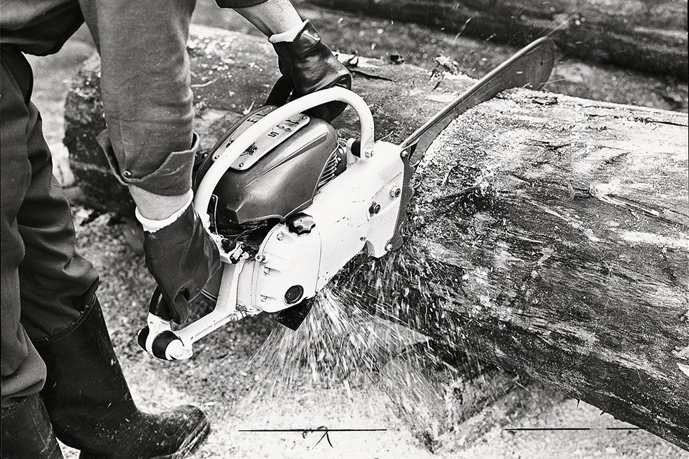Antigua imagen en blanco y negro de cómo alguien corta un árbol con la motosierra STIHL Contra 